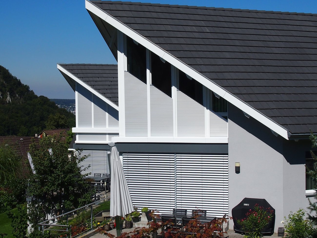  House with sloping roof and sloping roller shutter